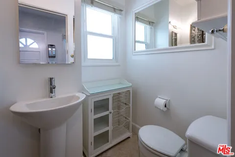 a bathroom with a sink a toilet and mirror