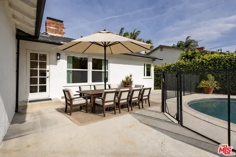 a view of a roof deck with table and chairs under an umbrella
