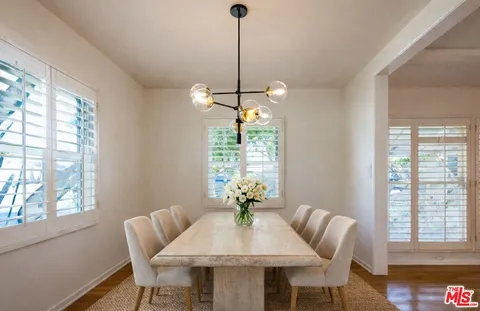 a dining room with furniture a chandelier and wooden floor