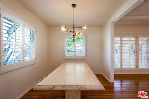 a view of empty room with window and wooden floor