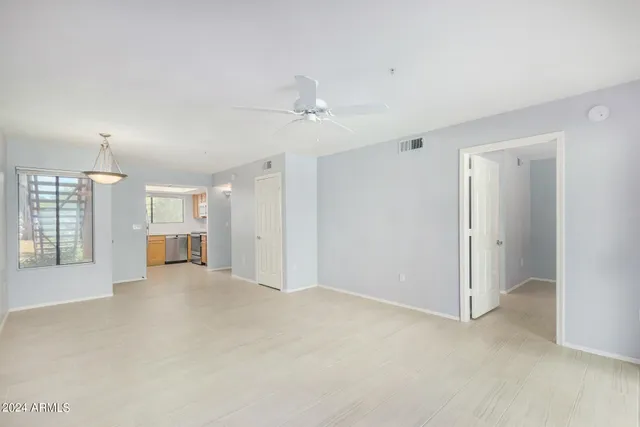 a view of a big room with windows and chandelier fan