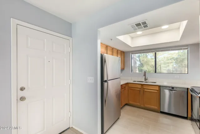 a kitchen with stainless steel appliances granite countertop a sink and dishwasher with white cabinets