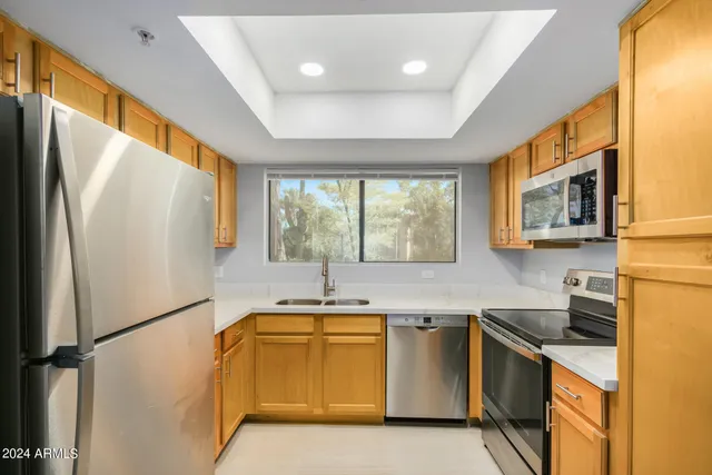 a kitchen with a refrigerator a sink and a stove top oven