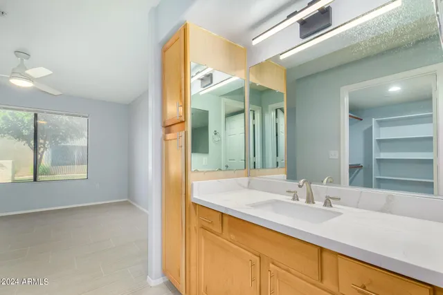a bathroom with a granite countertop sink and a large mirror