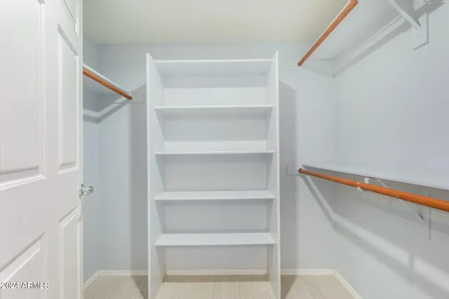 a view of walk in closet with empty racks