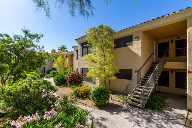 a front view of a house with lots of potted plants