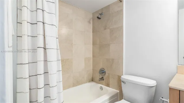 a white toilet sitting next to a bathroom sink and vanity