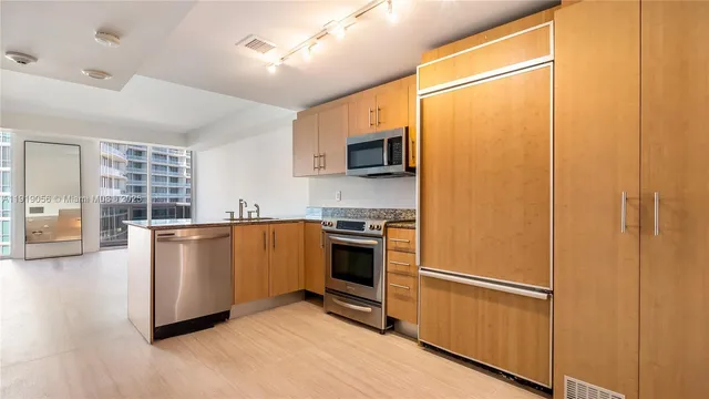 a kitchen with stainless steel appliances a refrigerator sink and microwave
