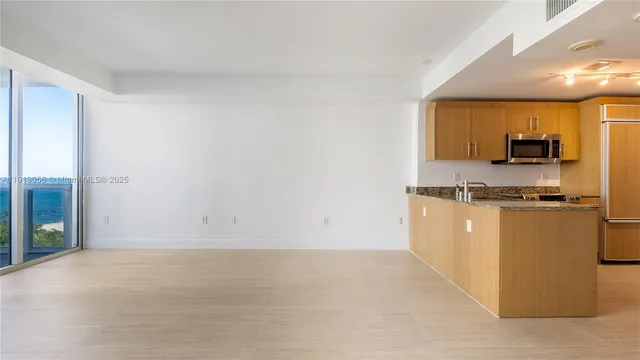 a view of kitchen with stainless steel appliances granite countertop cabinets and sink