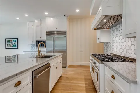 a kitchen with stainless steel appliances granite countertop a sink stove and cabinets