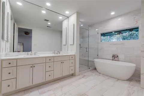 a spacious bathroom with a double vanity sink and a bathtub