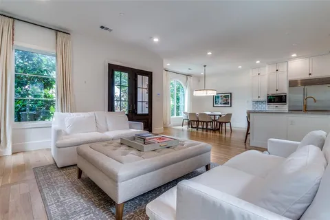 a living room with furniture kitchen view and a large window