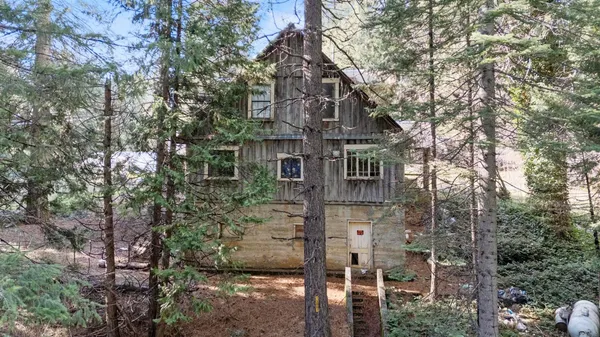 a view of a brick house with large trees