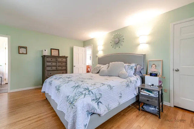 a bedroom with bed and wooden floor