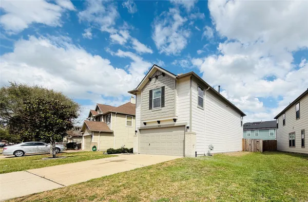 a view of a house with a yard and large tree