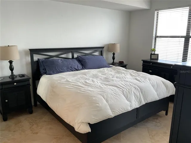 a bedroom with a bed and a window