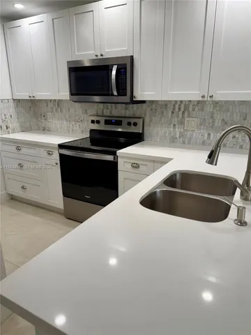 a kitchen with stainless steel appliances a stove sink microwave and cabinets