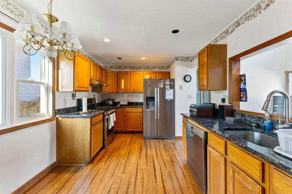 a kitchen with stainless steel appliances granite countertop sink stove top oven and refrigerator