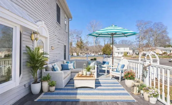 a view of a patio with couches table and chairs with wooden floor