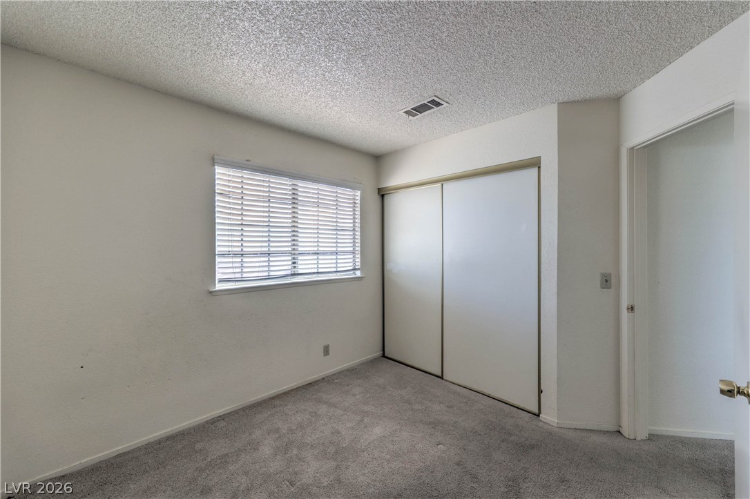 581 Carleton Drive Henderson, NV 89014 - Photo 20 of 37 A well-lit bedroom features plush gray carpeting and a practical sliding closet door.