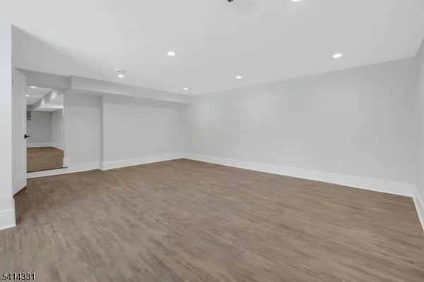 a view of empty room with wooden floor and cabinet