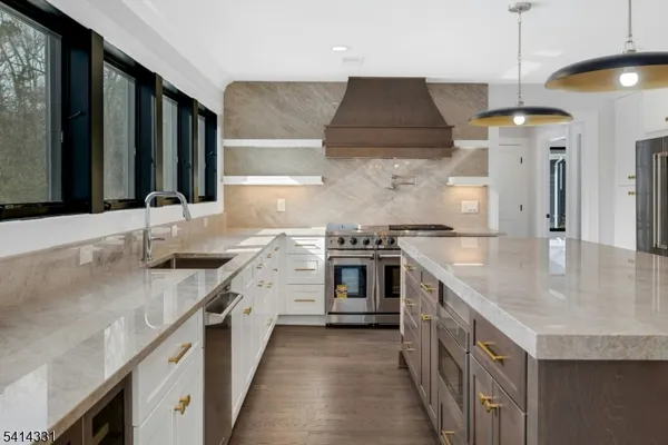 a kitchen with stainless steel appliances granite countertop a sink and a stove