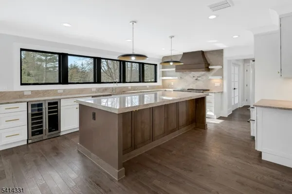 a kitchen with stainless steel appliances granite countertop a stove and a wooden floors