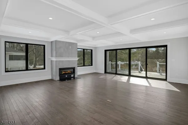 a view of an empty room with wooden floor and a fireplace