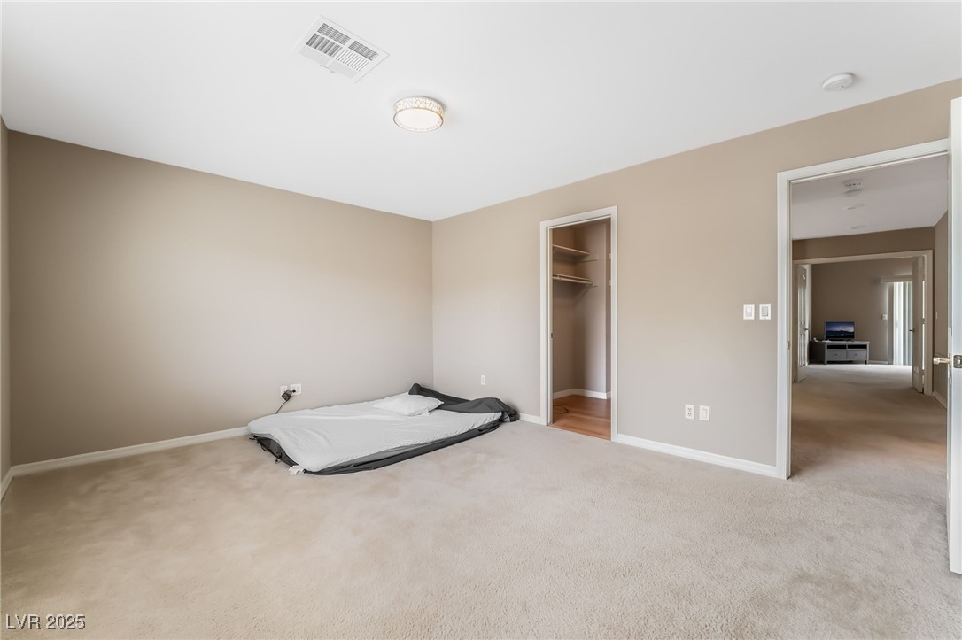 2392 Rainswept Avenue Henderson, NV 89052 - Photo 35 of 49 Unfurnished bedroom featuring a spacious closet, baseboards, visible vents, and carpet floors