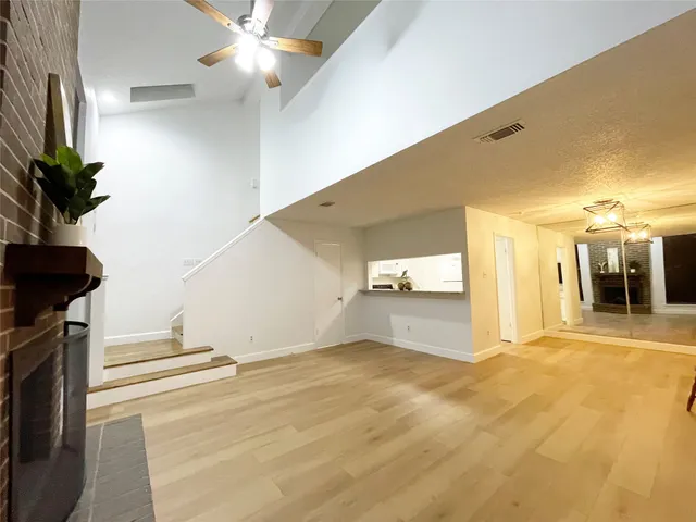 a view of a hallway with wooden floor and a potted plant
