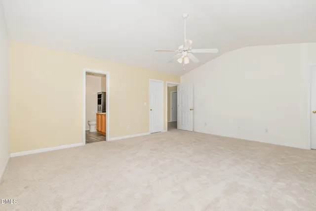 an empty room with an entryway and fan