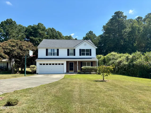 a view of a house with a yard and potted plants