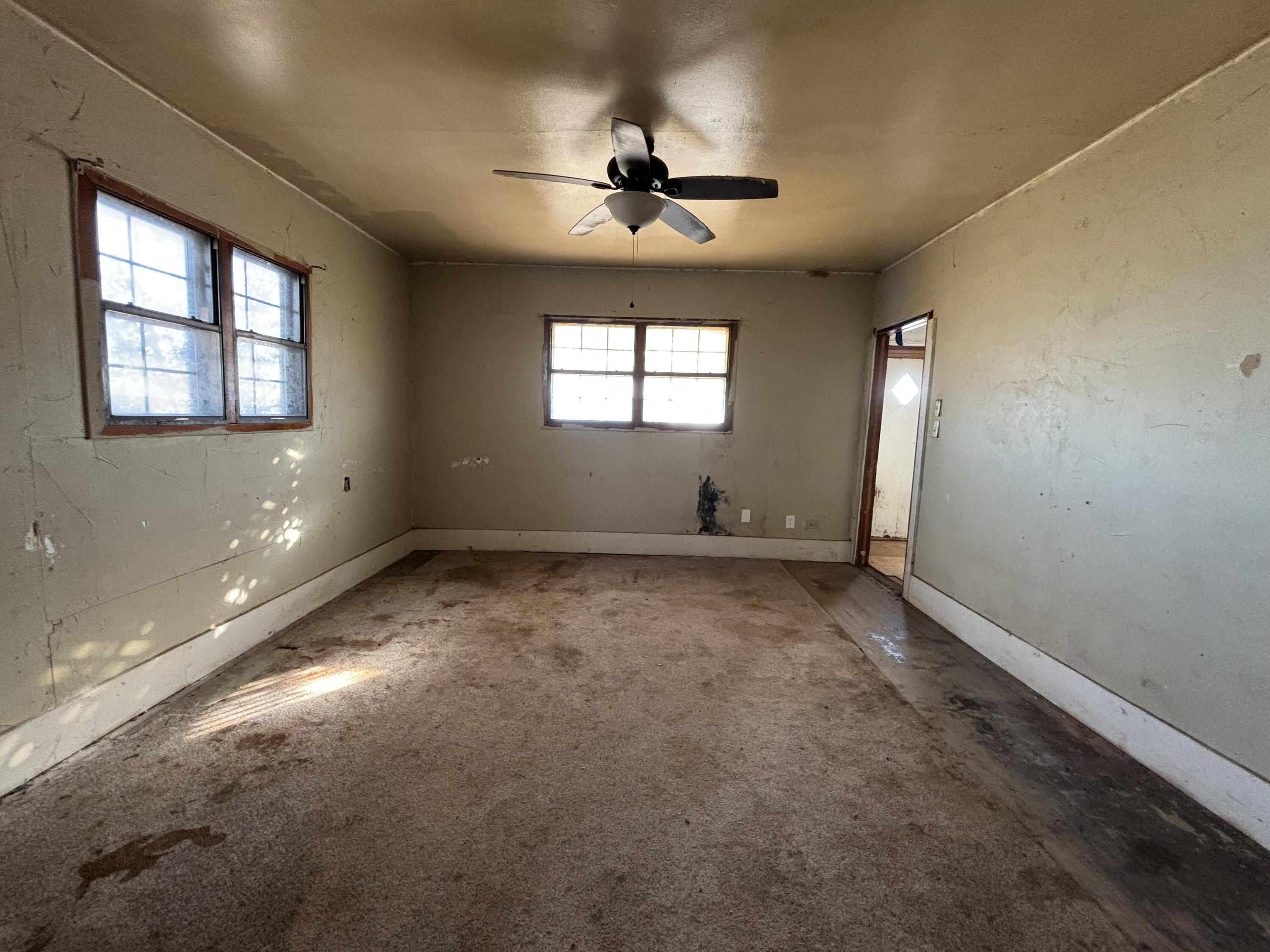 311 11th Street Ralls, TX 79357 - Photo 11 of 21 an empty room with a ceiling fan and window