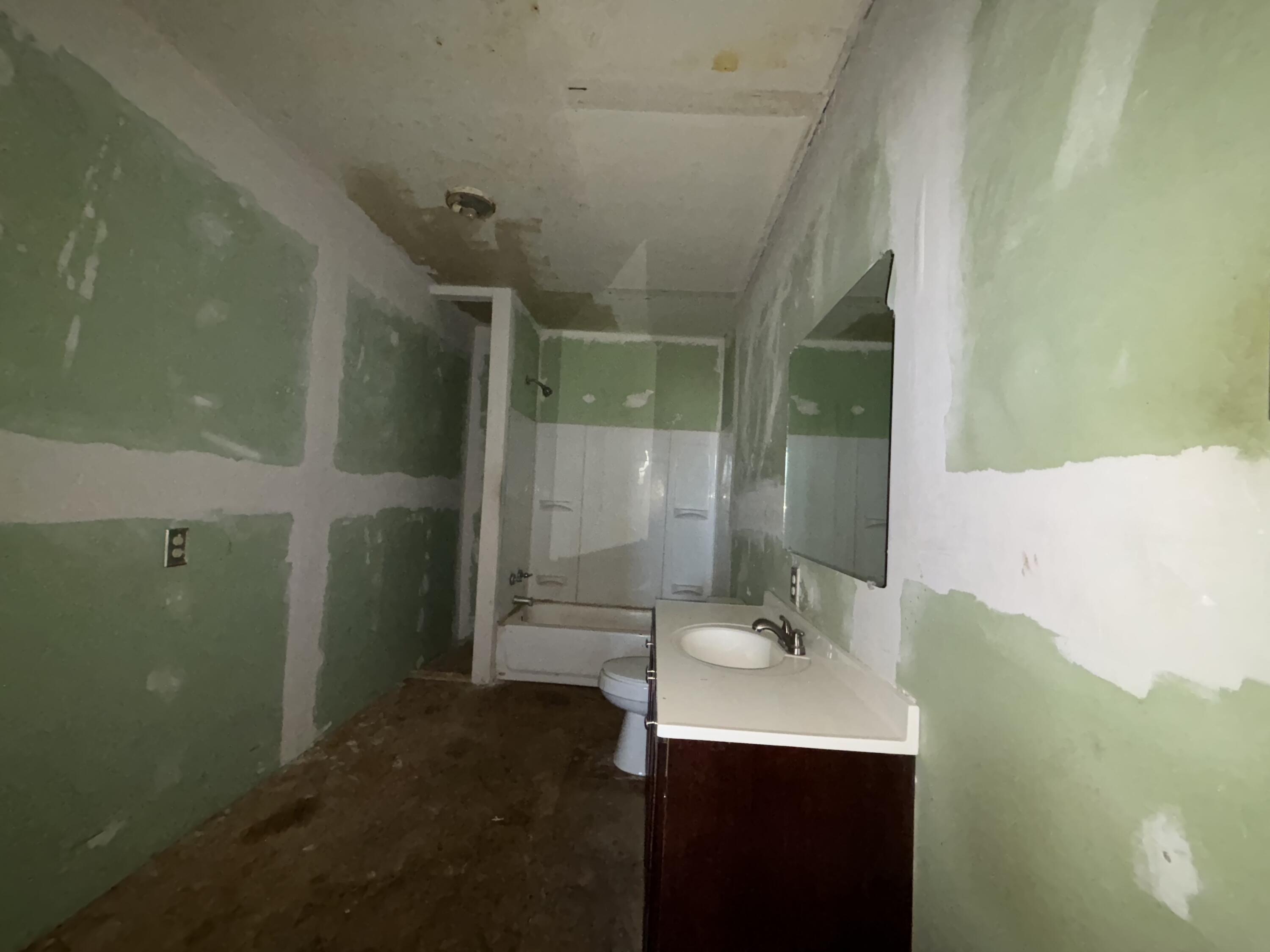 311 11th Street Ralls, TX 79357 - Photo 13 of 21 a bathroom with a sink mirror and shower