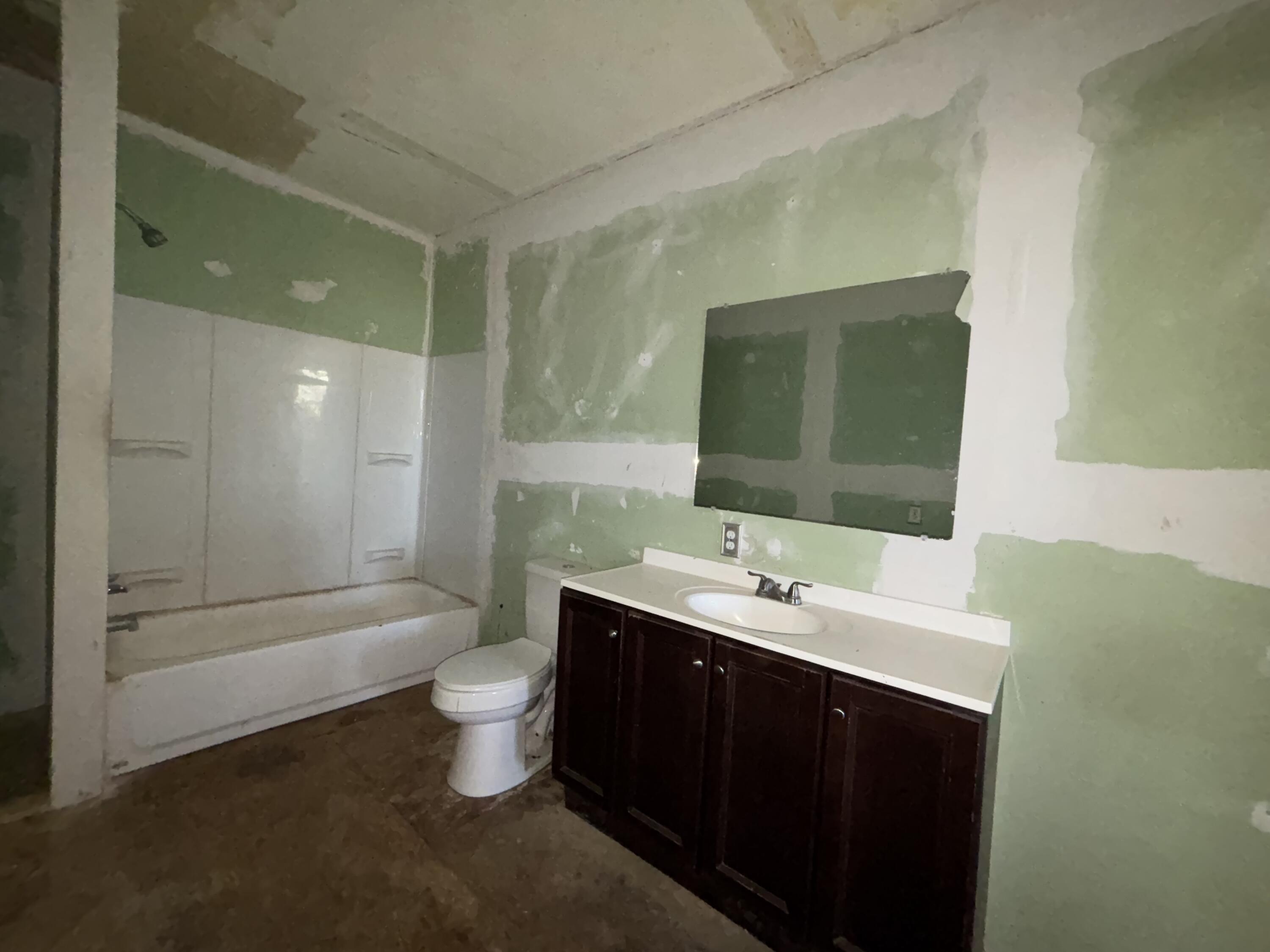 311 11th Street Ralls, TX 79357 - Photo 14 of 21 a bathroom with a double vanity sink toilet and shower