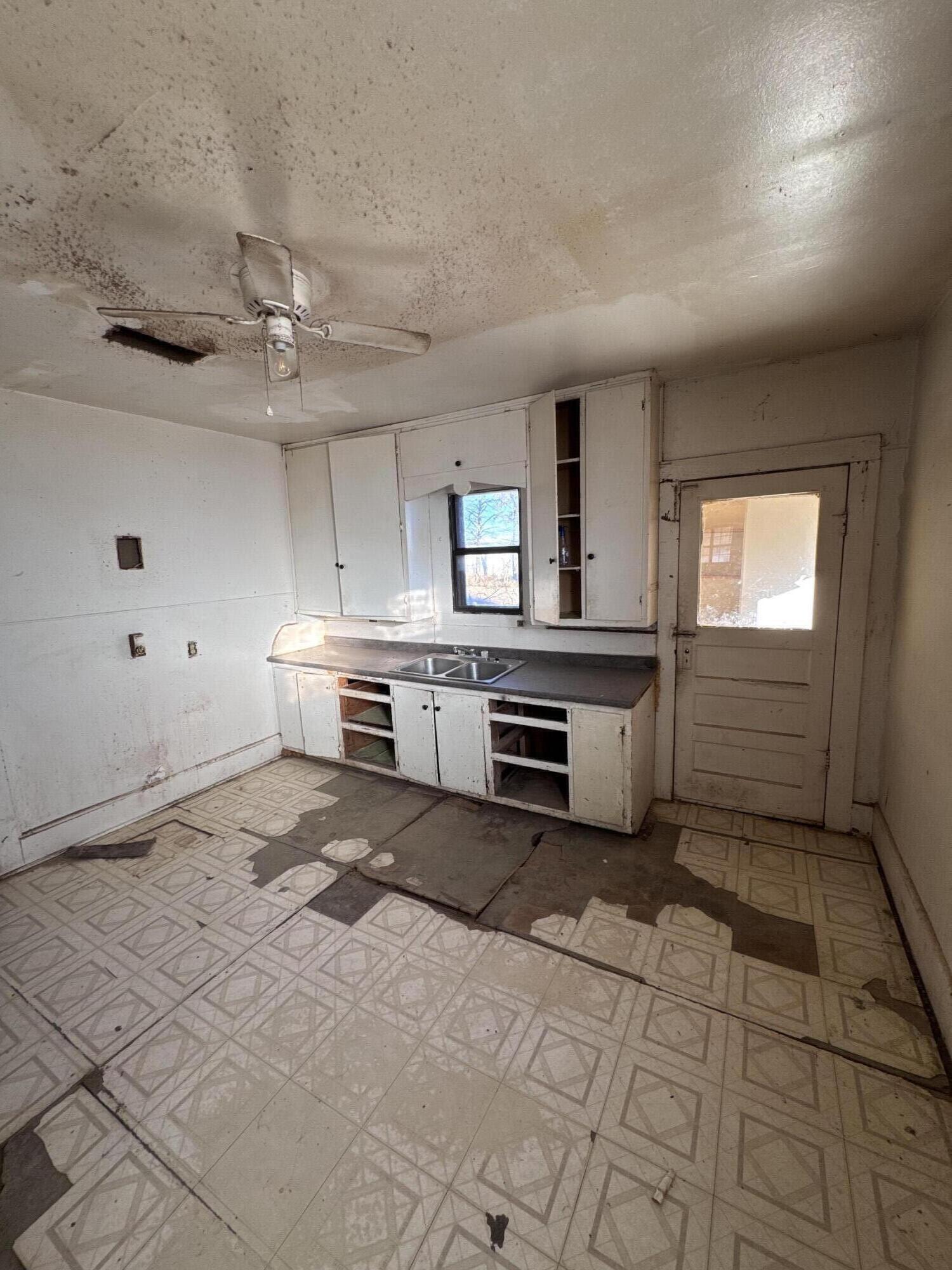 311 11th Street Ralls, TX 79357 - Photo 4 of 21 a kitchen with a stove a sink and a refrigerator