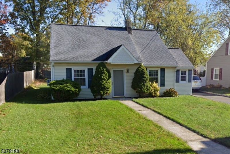 a front view of a house with a garden and trees