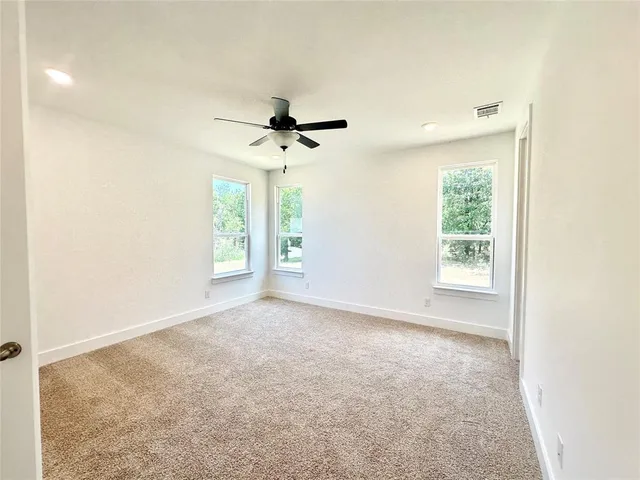 a view of a livingroom with a ceiling fan and window