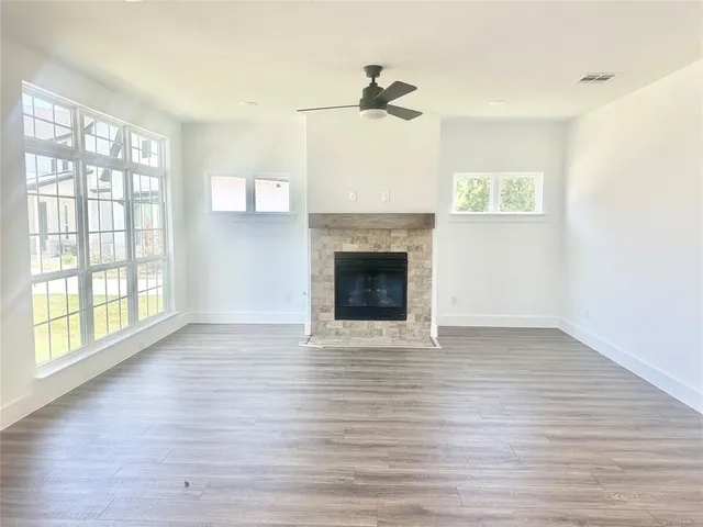 a view of an empty room with glass door and wooden floor