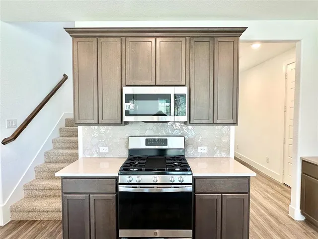 a stove top oven sitting inside of a kitchen