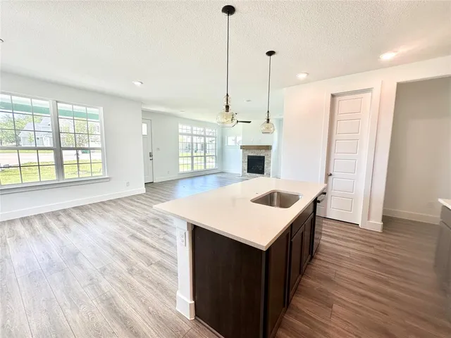 a kitchen with a stove and white cabinets with wooden floor
