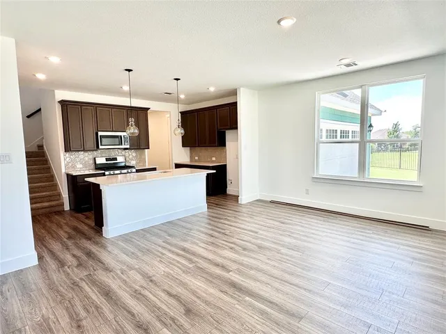 a large kitchen with stainless steel appliances granite countertop a stove and a sink