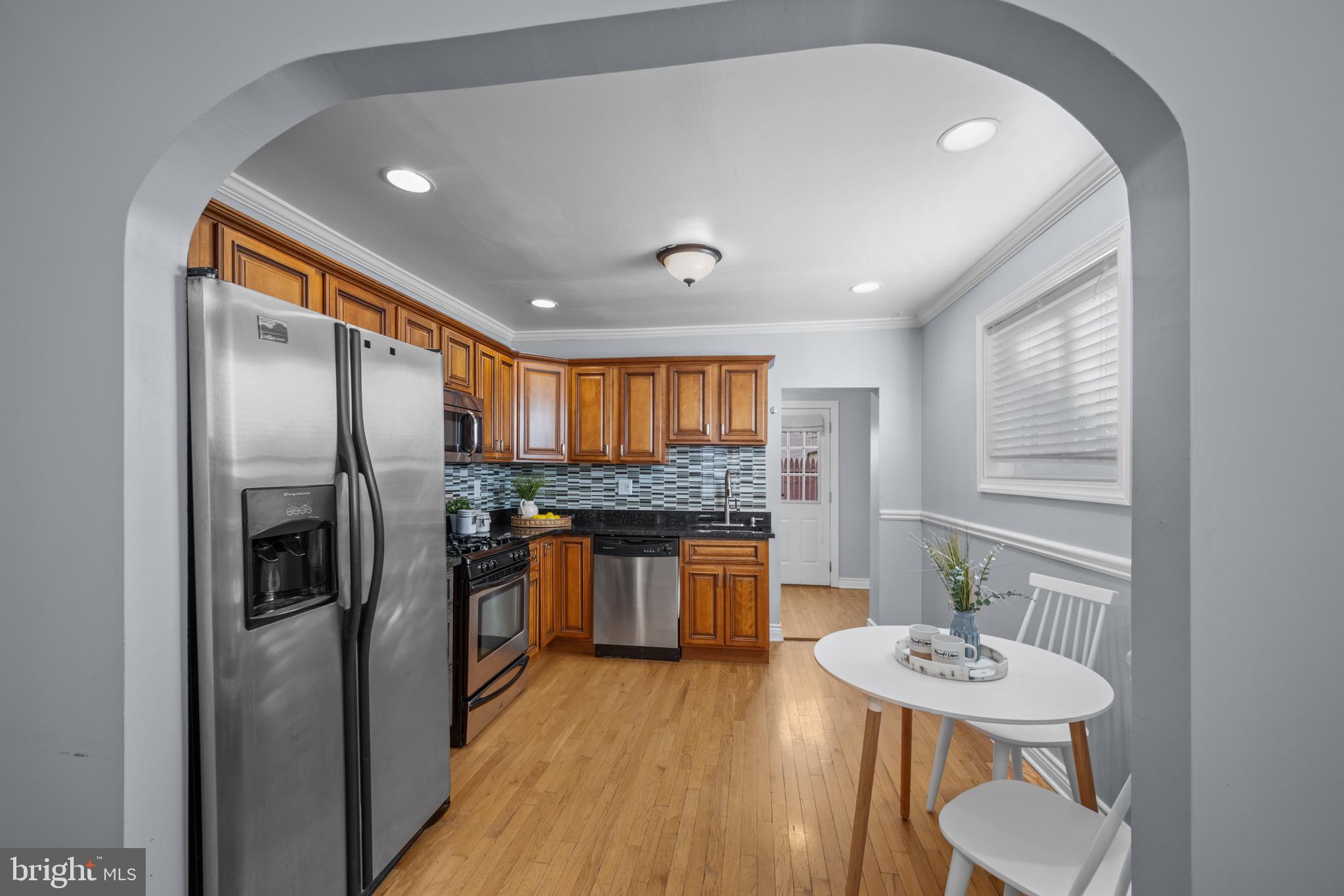 17 West Fort Avenue Baltimore, MD 21230 - Photo 8 of 43 a kitchen with stainless steel appliances granite countertop a refrigerator a sink a stove and island with wooden floor