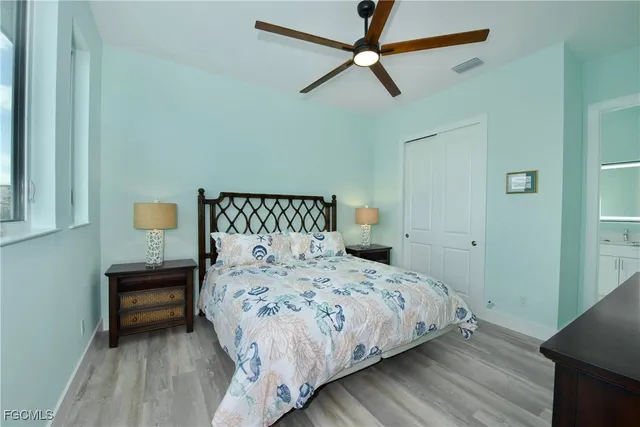 a bedroom with a bed a dresser and a chandelier