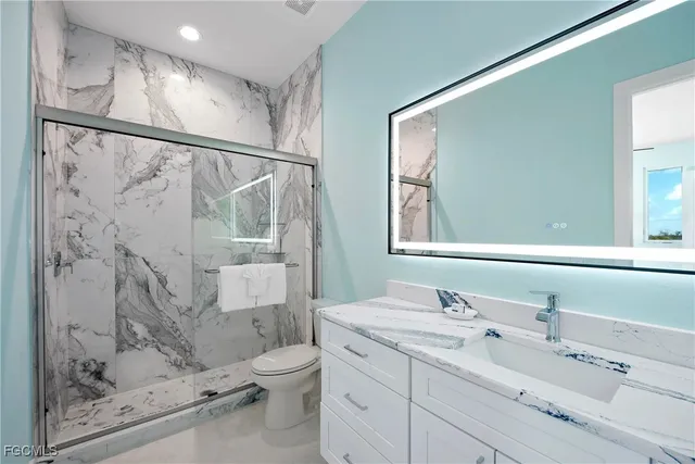 a bathroom with a granite countertop sink toilet and shower