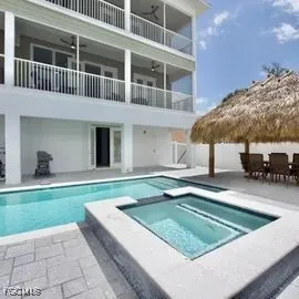 a view of a house with swimming pool and sitting area
