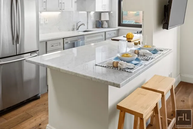 a kitchen with a sink a stove and chairs with wooden floor