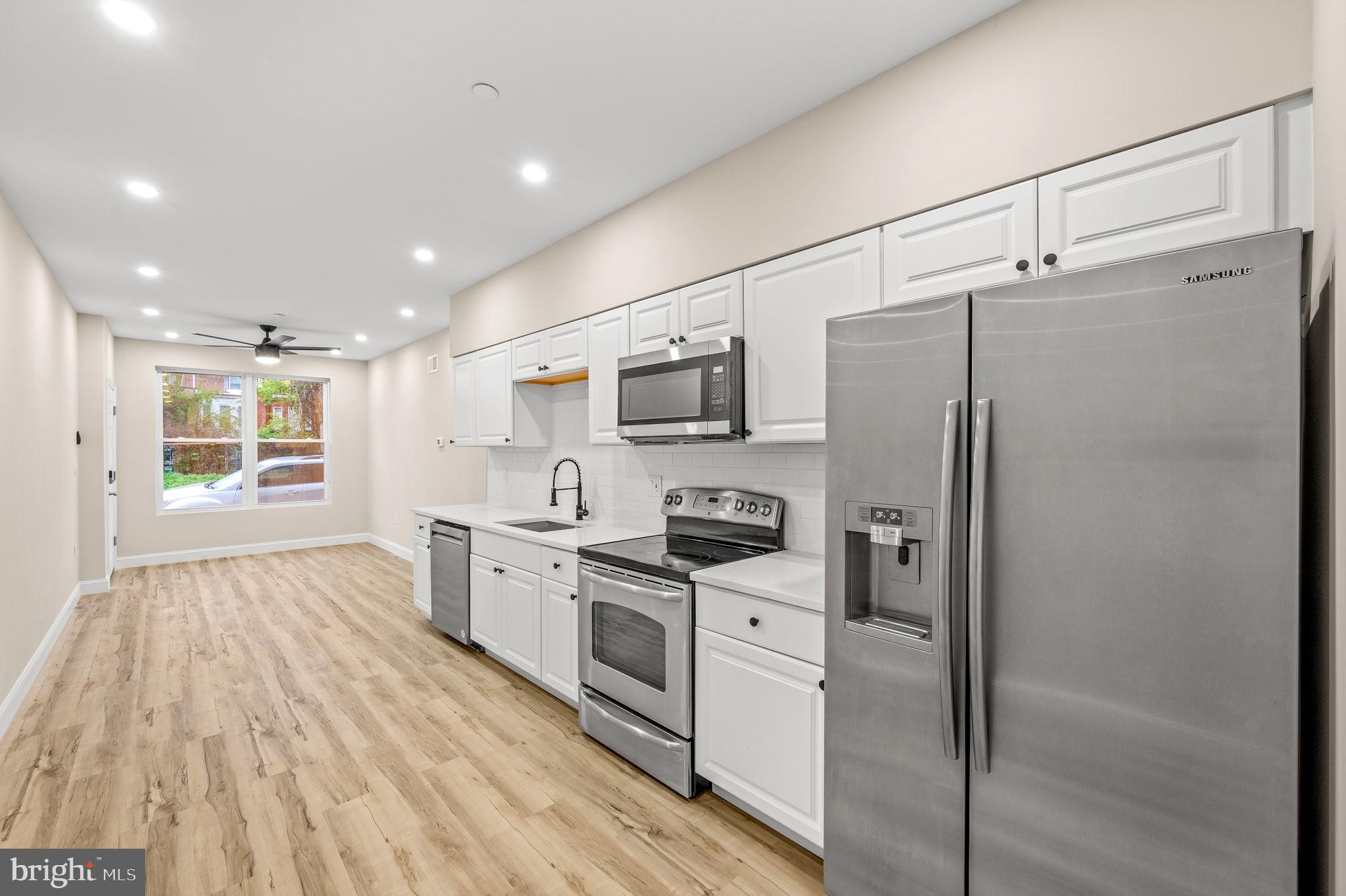 2134 North 19th Street, Unit 1 Philadelphia, PA 19121 - Photo 1 of 10 a kitchen with stainless steel appliances a refrigerator sink and microwave