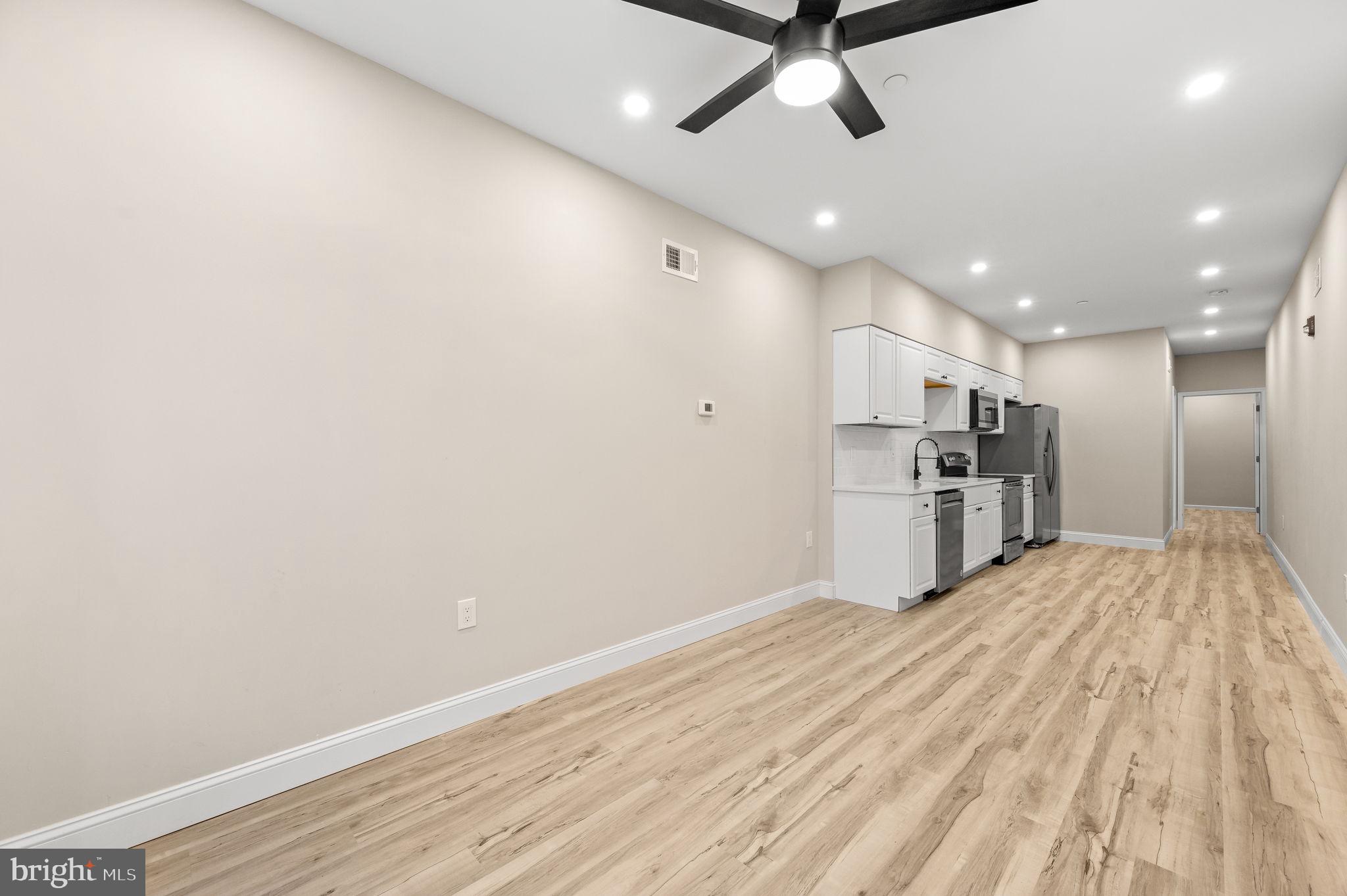 2134 North 19th Street, Unit 1 Philadelphia, PA 19121 - Photo 2 of 10 a view of a kitchen with stainless steel appliances wooden floor and staircase