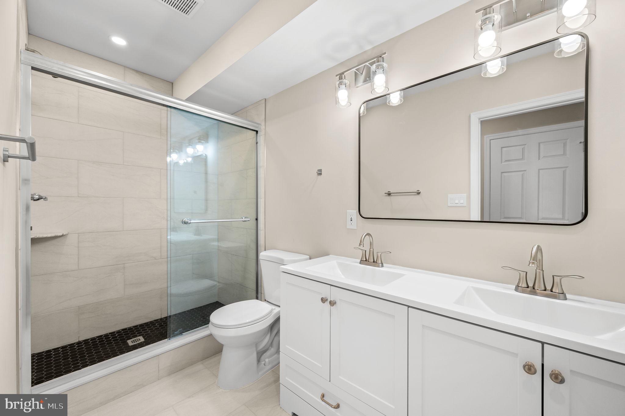 2134 North 19th Street, Unit 1 Philadelphia, PA 19121 - Photo 4 of 10 a bathroom with a toilet a sink a mirror and a shower